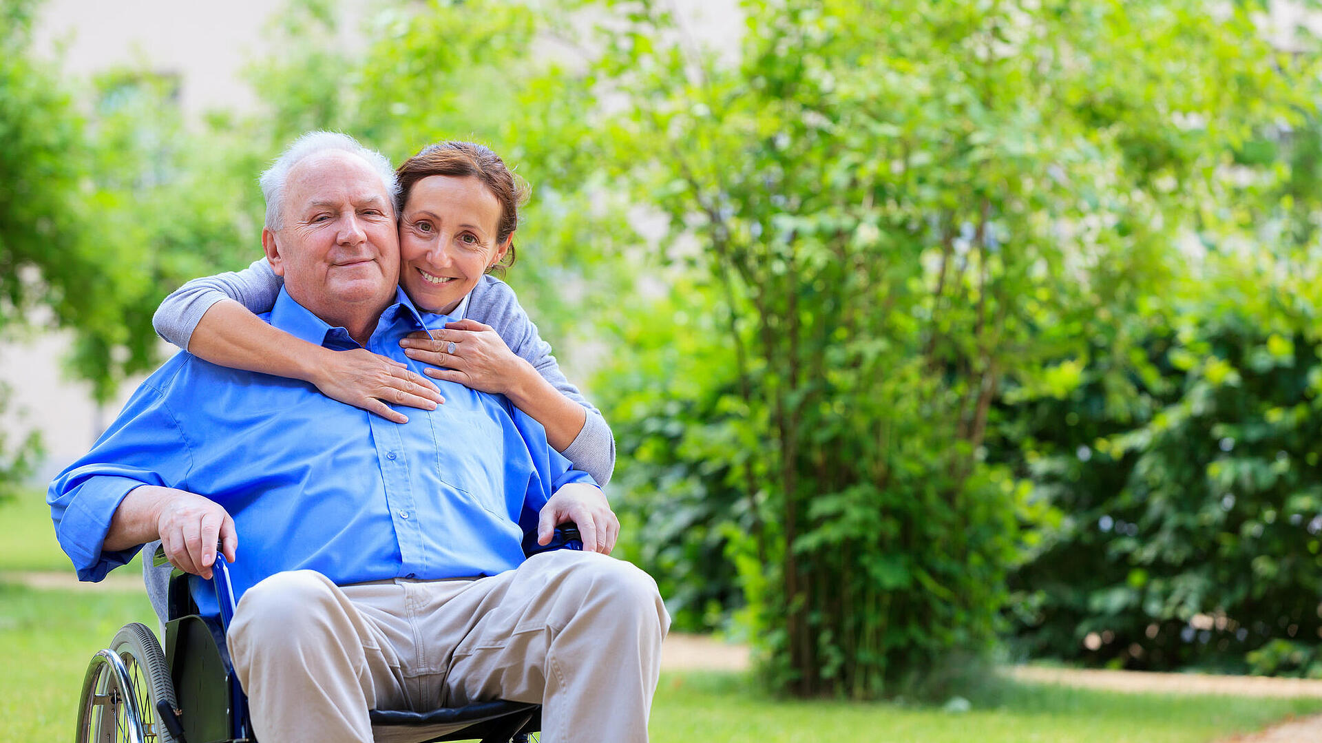 Frau mit Vater im Rollstuhl