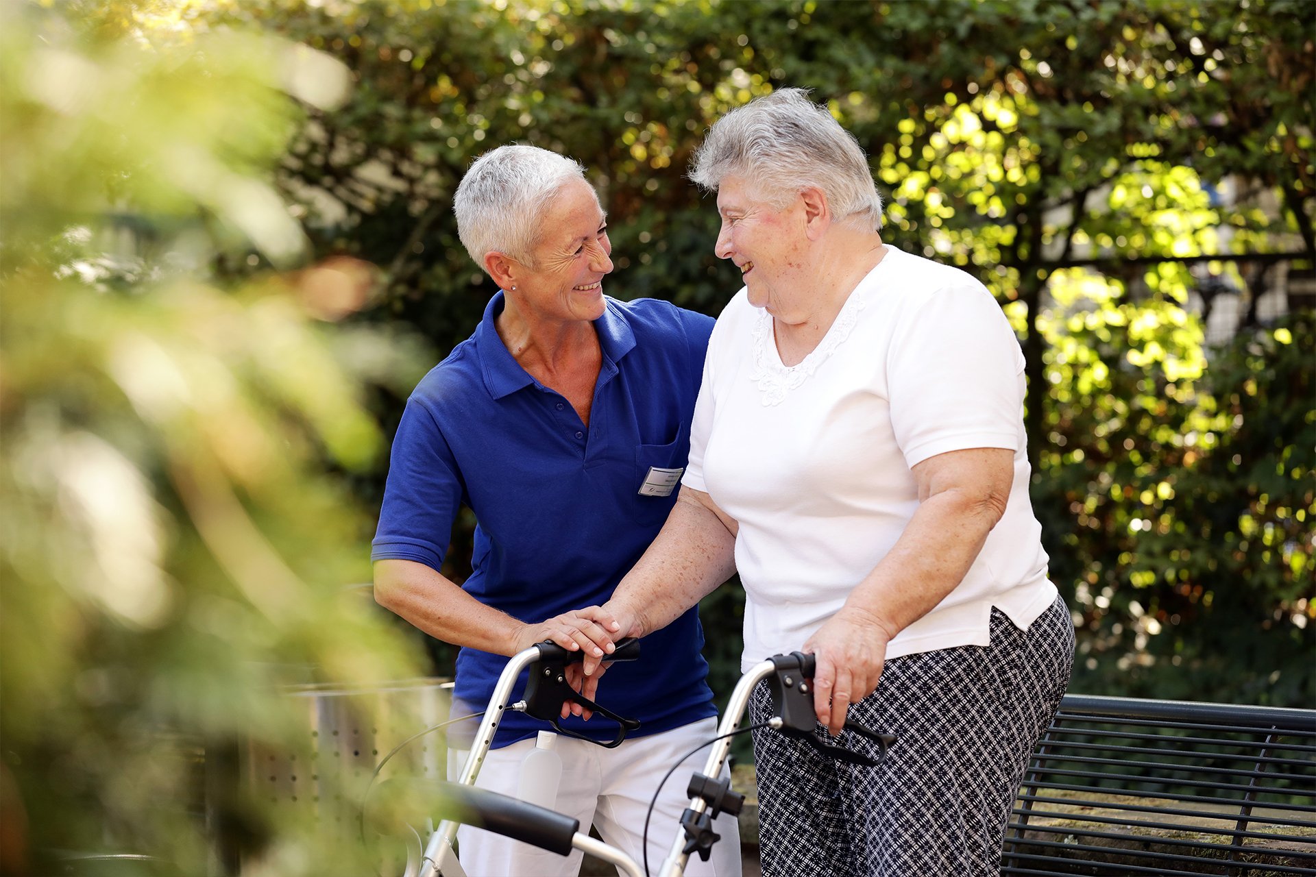 Patientin am Rollator mit Pflegekraft