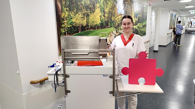 Pflegekraft Julia Polzin auf Station mit Puzzleteil in der Hand