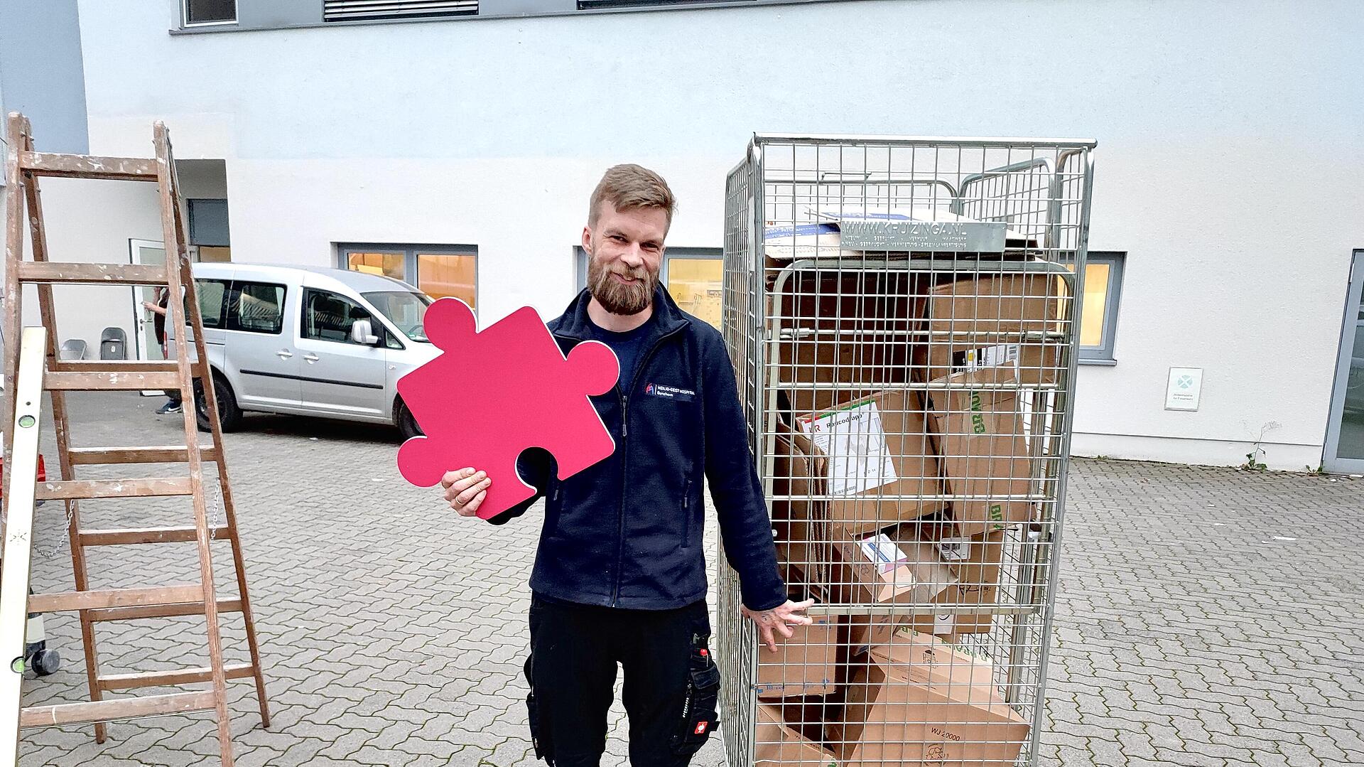 Haustechniker Simon Egerer mit Puzzleteil in der Hand