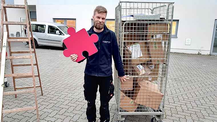 Haustechniker Simon Egerer mit Puzzleteil in der Hand