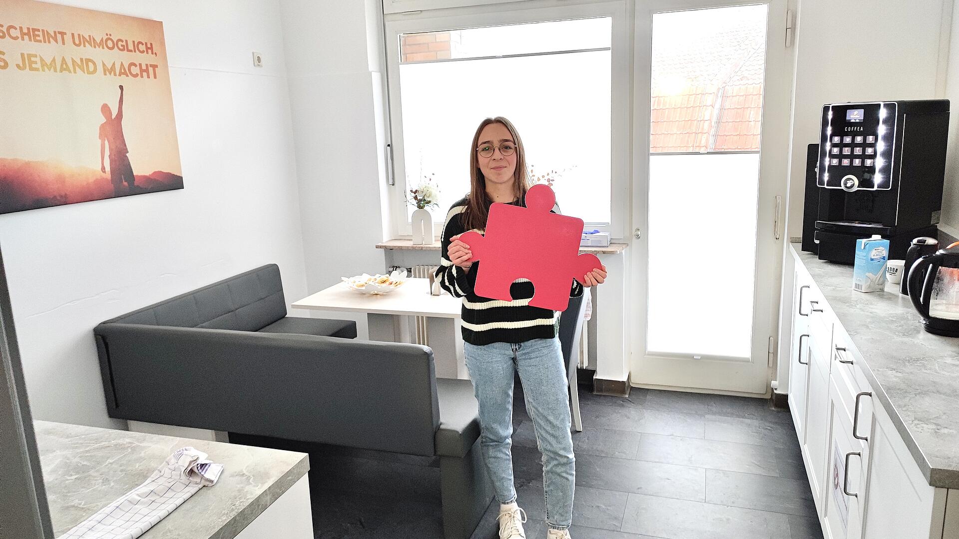Lena Bach von der Personalabteilung mit Puzzleteil in der Hand