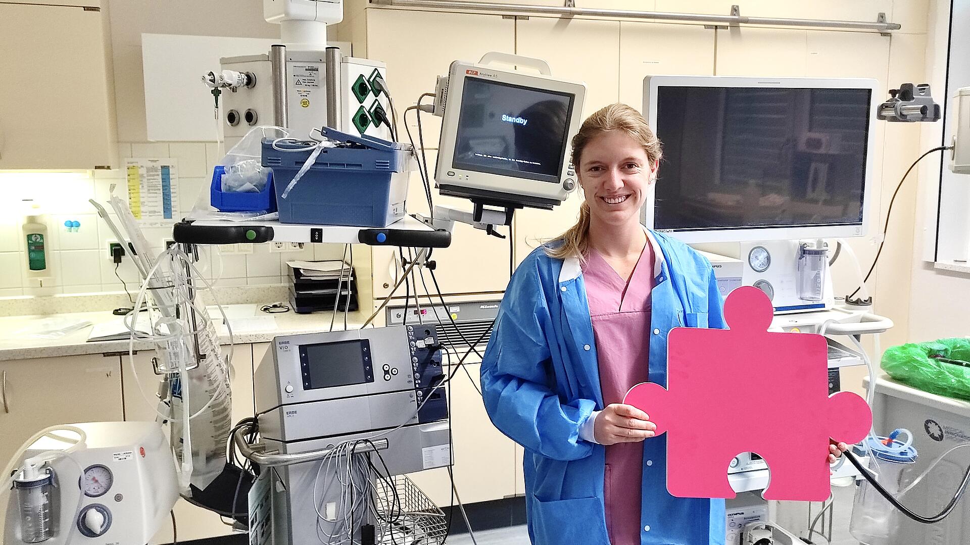 Endoskopiepflegekraft Lisa Pfitzenreuter mit Puzzleteil in der Hand