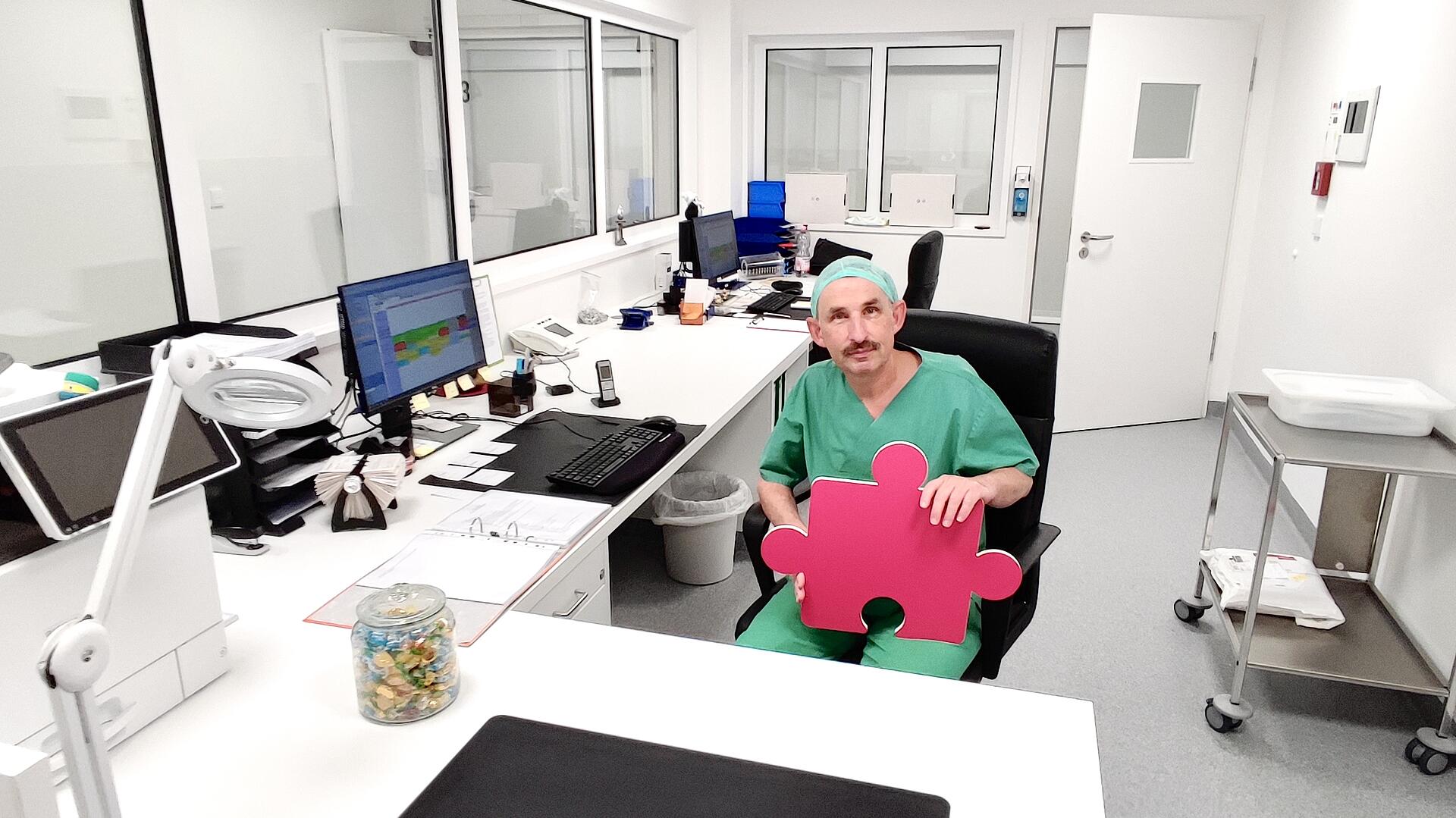 OP-Leitung Guido Kunz mit Puzzleteil in der Hand